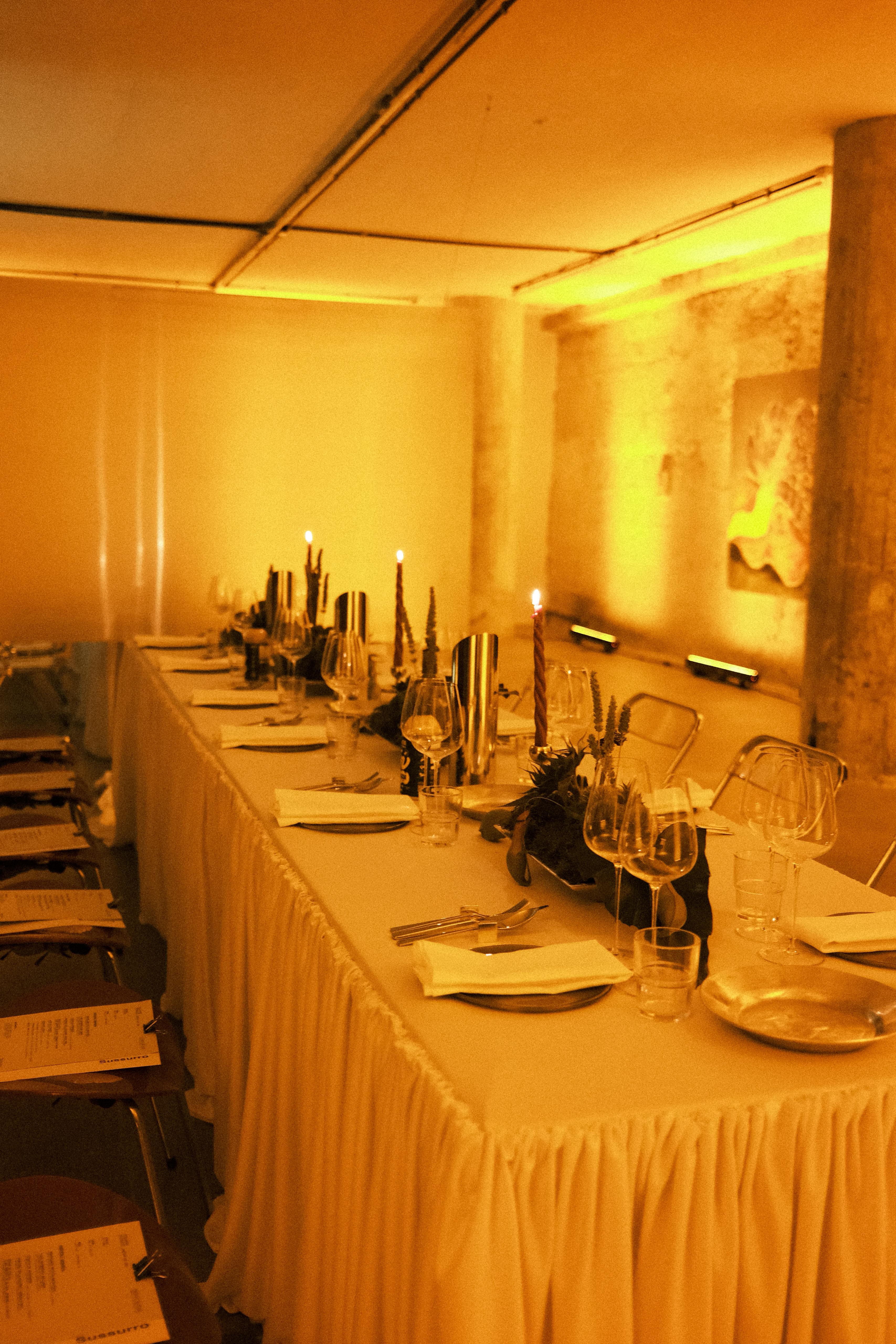 Long candlelit table set in amber light