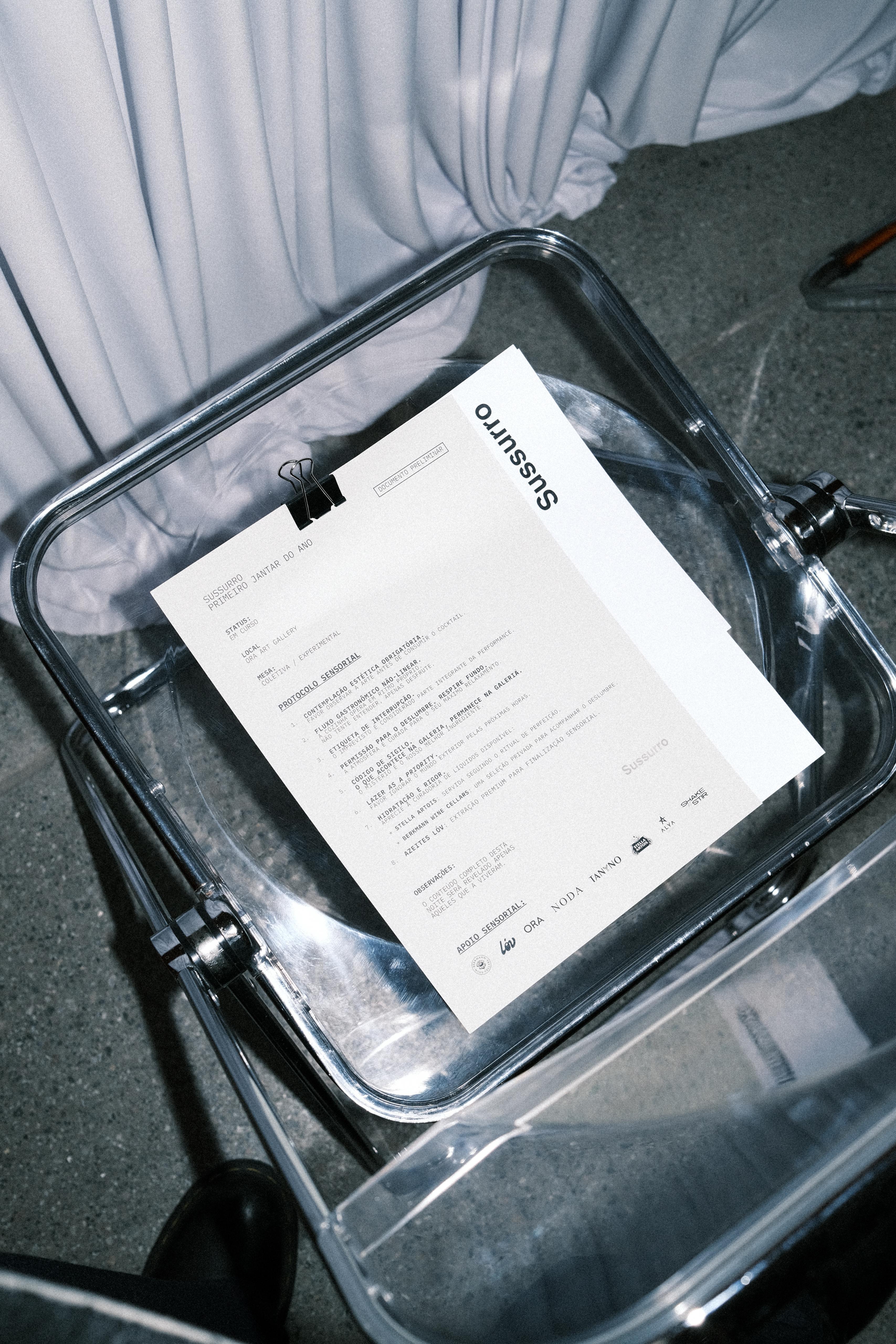 Sussurro menu resting on an acrylic chair